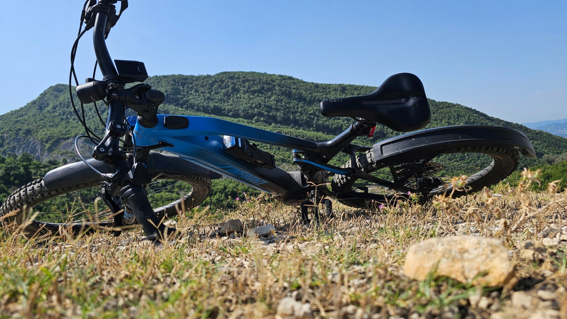 E-Bike liegt in der Natur vor einem Hügel